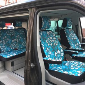 Sitze eines Fahrzeugs mit blumigen Mustern in Türkis.